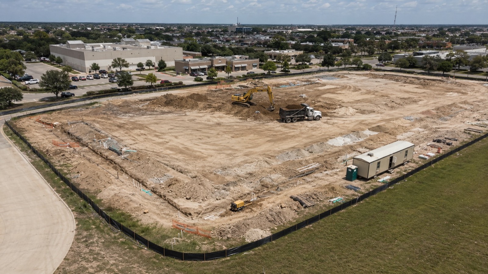 Active commercial site development project in Greater Houston with grading, utility trenches, and a vertical-ready building pad &mdash; cover image for the commercial site development process guide