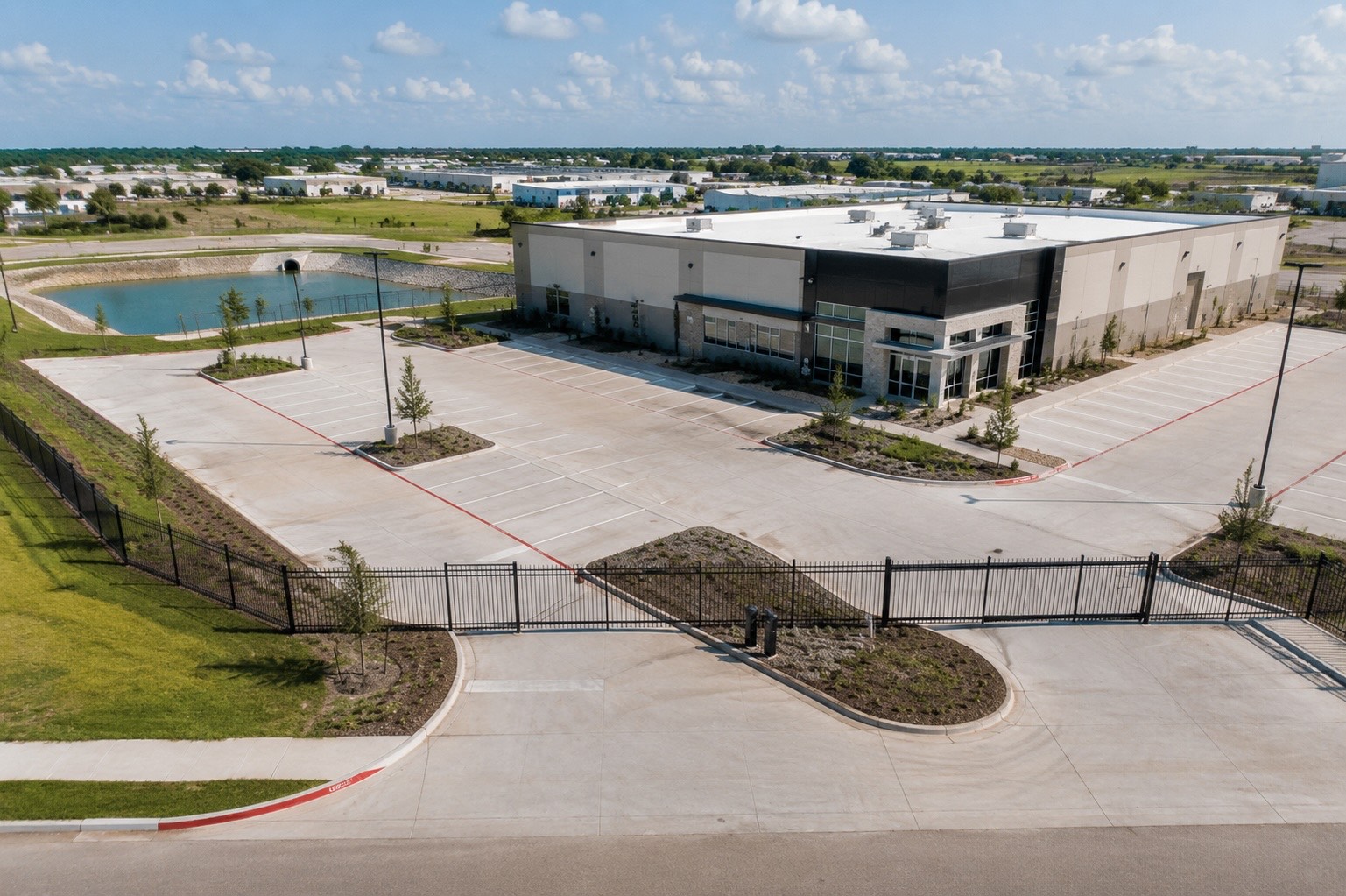 Finished commercial pad with paving, lighting, and perimeter fence &mdash; cover image for the commercial site development guide